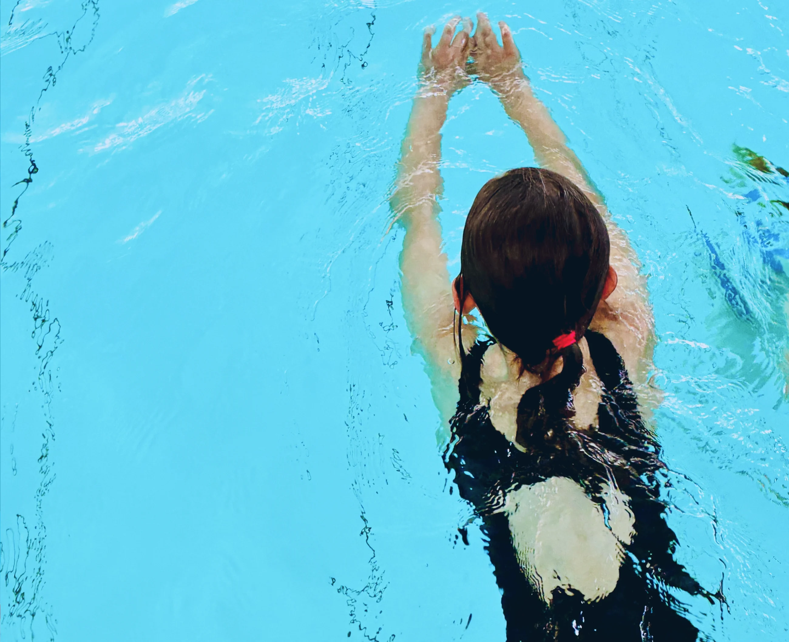 Kind schwimmt in der Delfingruppe durch das Becken der Aquarena Neunkirchen-Seelscheid