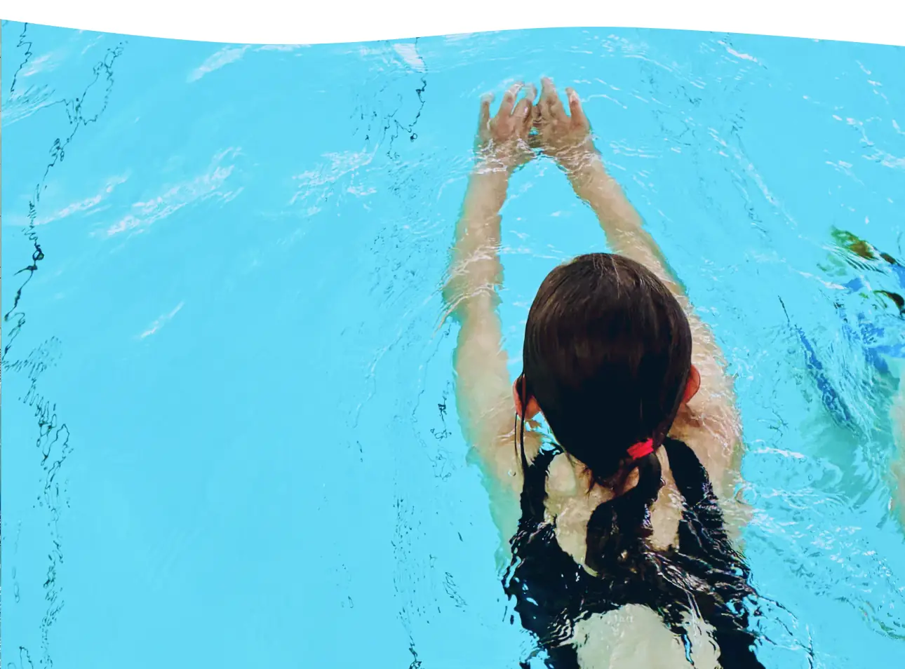 Kind schwimmt in der Delfingruppe durch das Becken der Aquarena Neunkirchen-Seelscheid