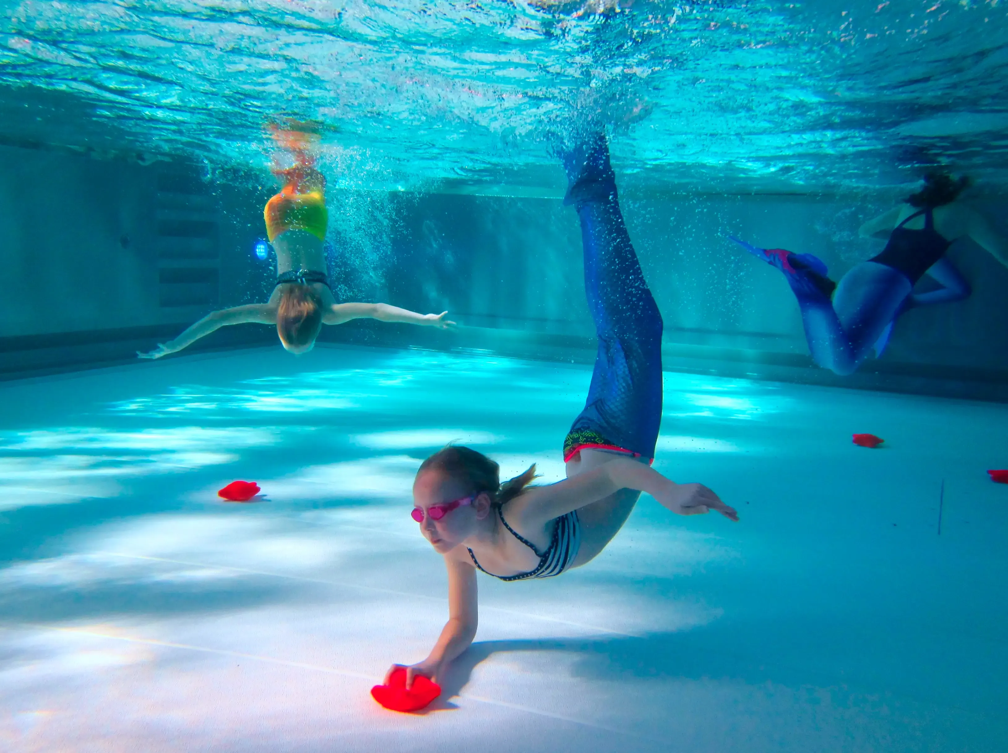 Kind mit Monoflosse gleitet im Mermaid-Level-1-Kurs durch das Becken der Aquarena Neunkirchen-Seelscheid