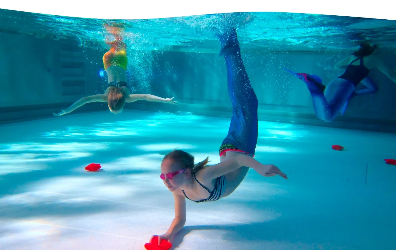 Kind mit Monoflosse gleitet im Mermaid-Level-1-Kurs durch das Becken der Aquarena Neunkirchen-Seelscheid