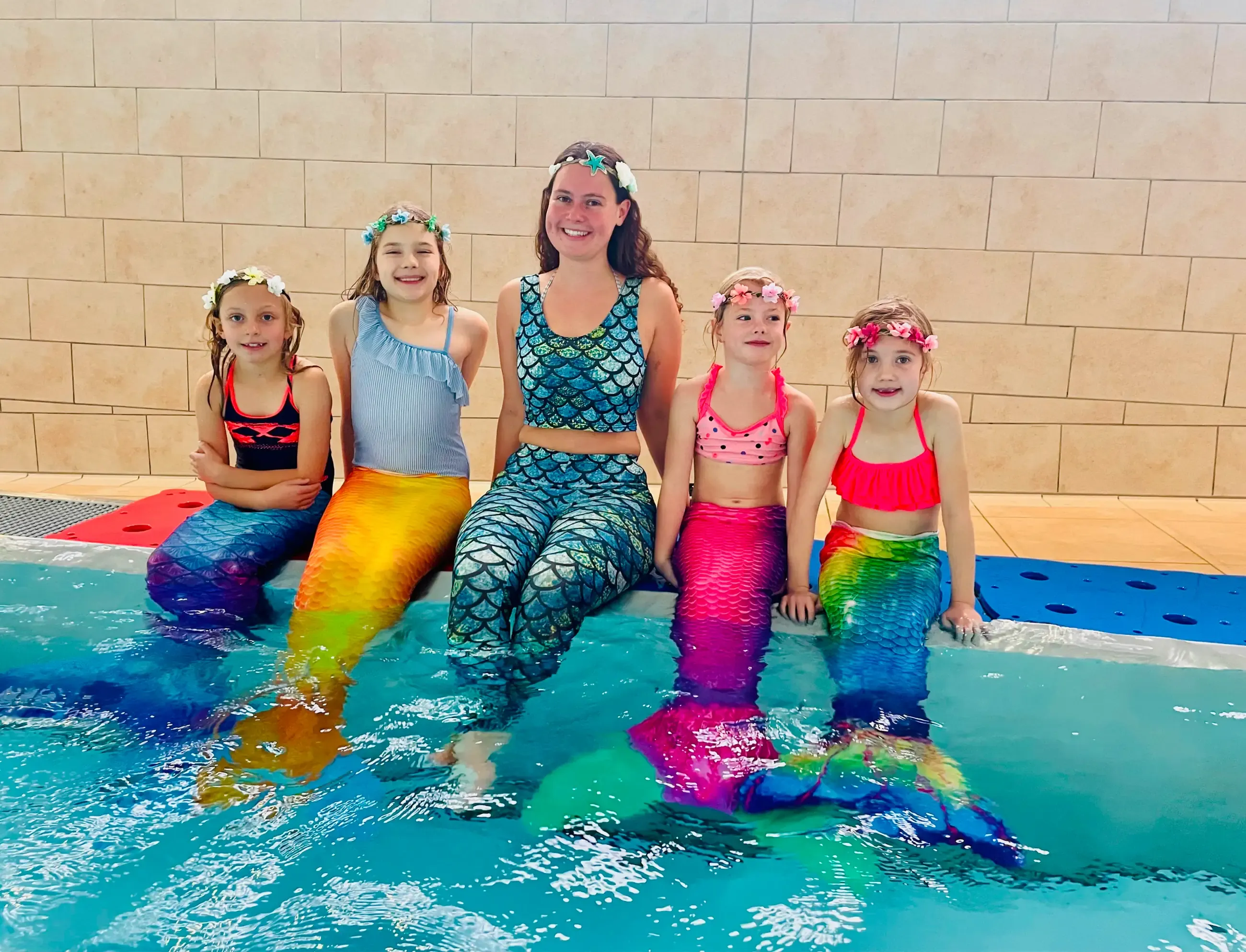 Kinder mit Meerjungfrauenflossen am Beckenrand der Aquarena Neunkirchen-Seelscheid bei einer Nixenparty