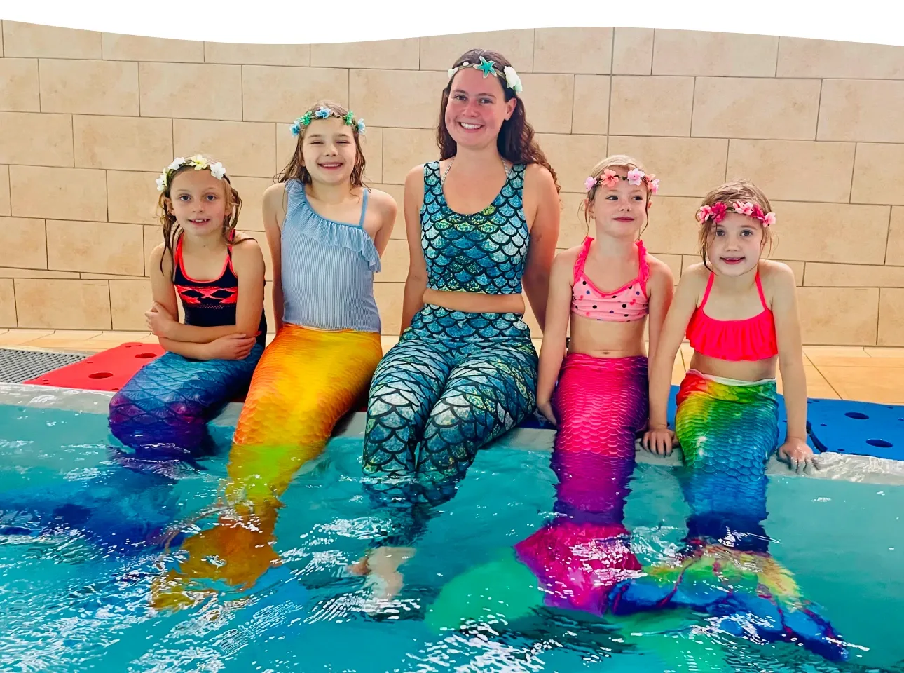 Kinder mit Meerjungfrauenflossen am Beckenrand der Aquarena Neunkirchen-Seelscheid bei einer Nixenparty