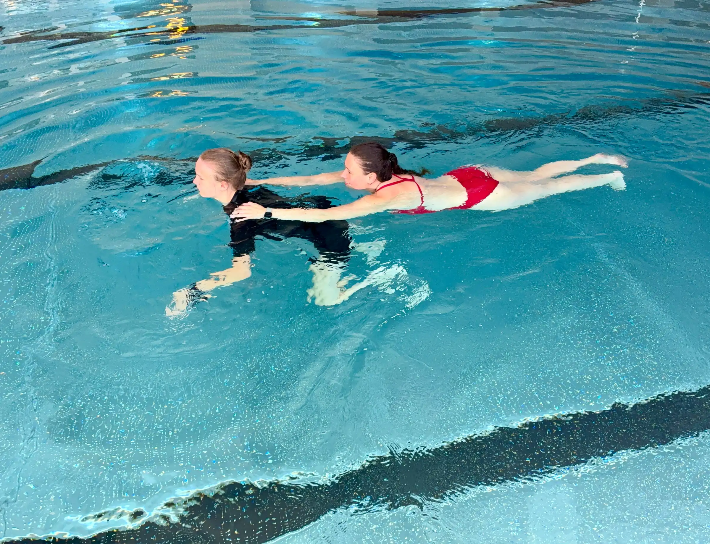Kind übt im Rettungsschwimmkurs das Abschleppen einer Person im Becken der Aquarena Neunkirchen-Seelscheid