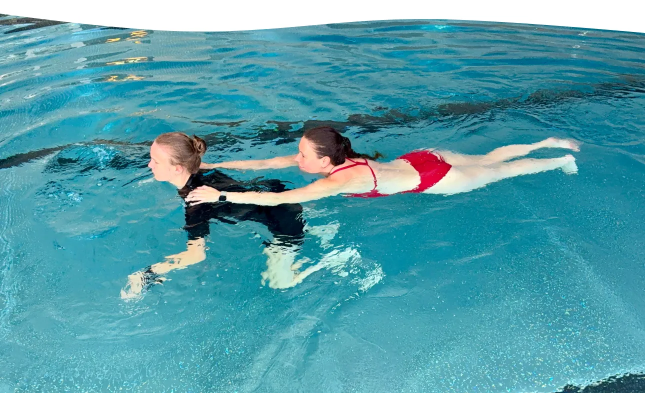 Kind übt im Rettungsschwimmkurs das Abschleppen einer Person im Becken der Aquarena Neunkirchen-Seelscheid