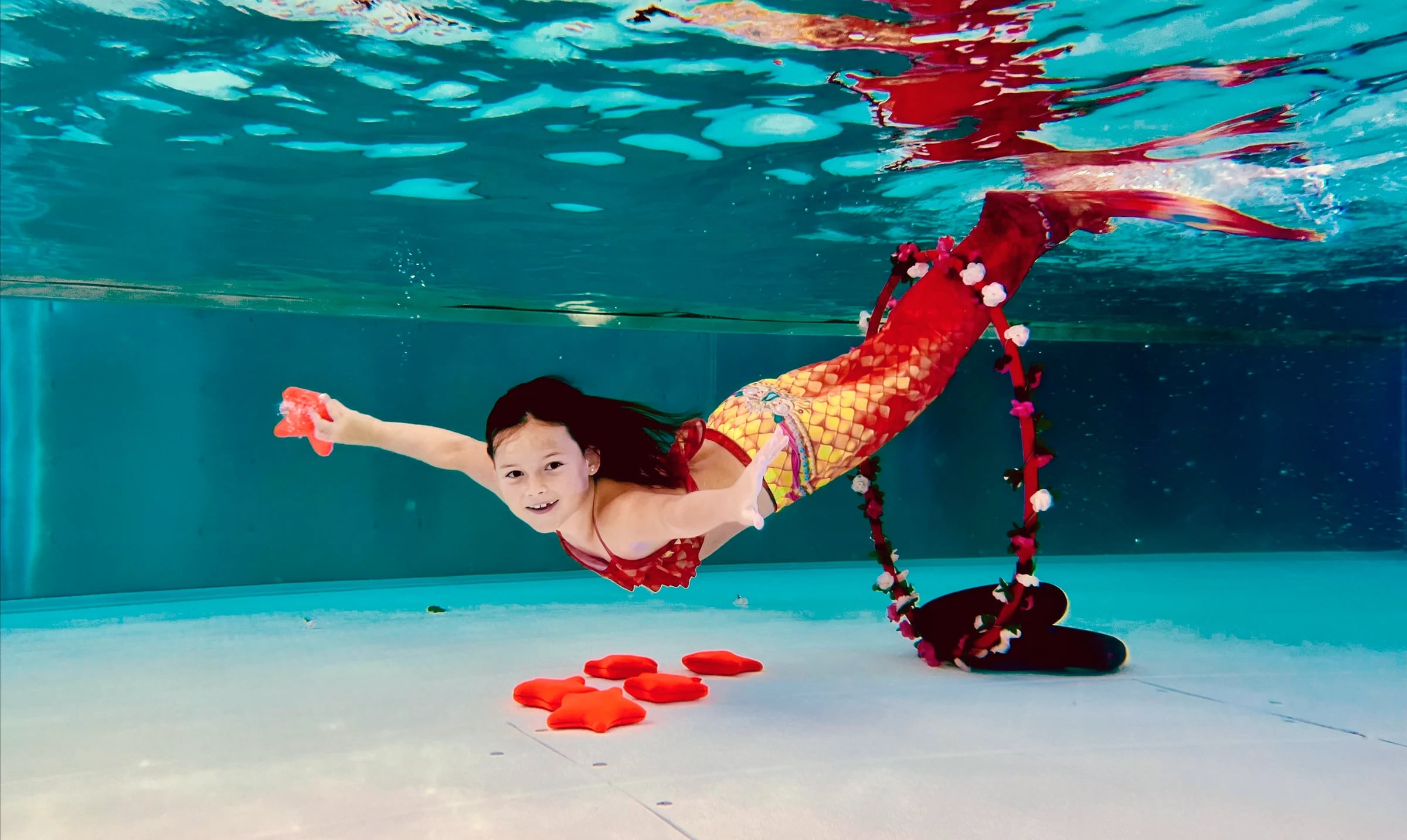 Mädchen mit Monoflosse beim Mermaiding unter Wasser