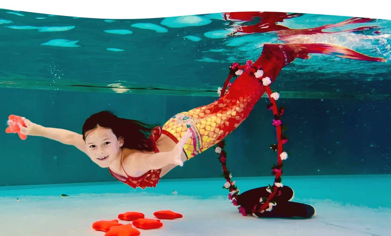 Mädchen mit Monoflosse beim Mermaiding unter Wasser