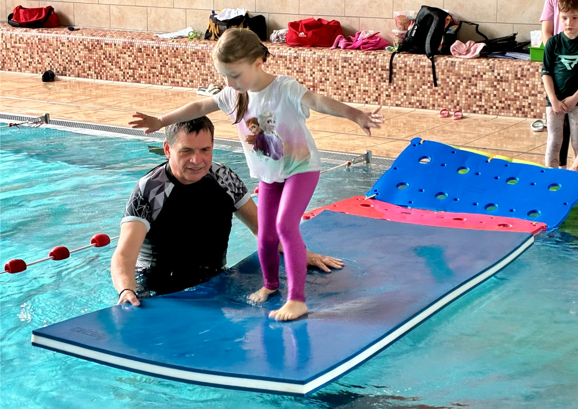 Kind schwimmt in Kleidung beim Abschlusstag des Wasser-Sicherheitskurses in der Aquarena Neunkirchen-Seelscheid